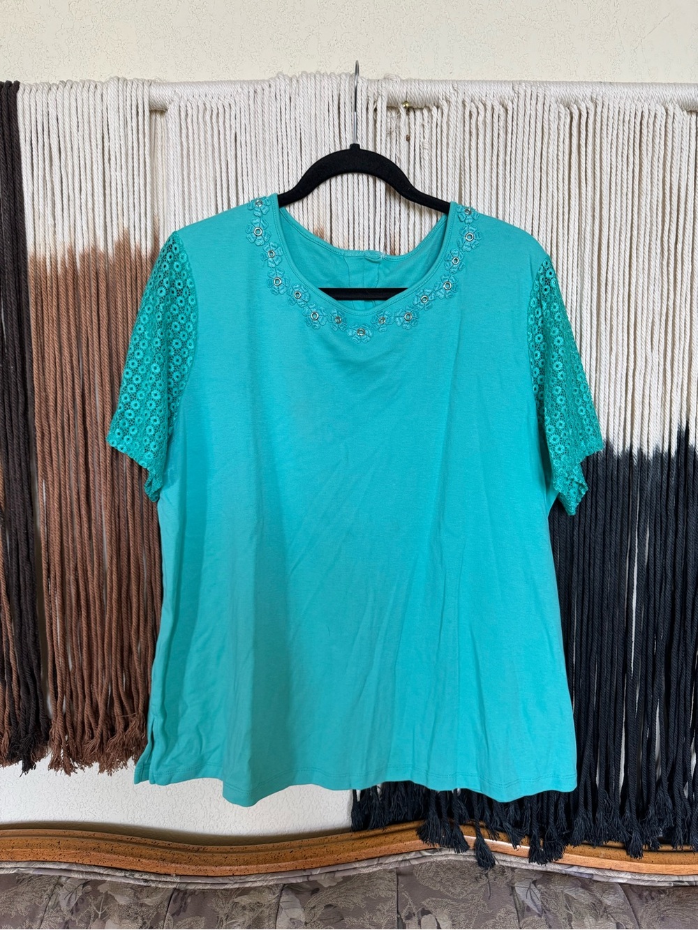 Teal blue short sleeve top with floral neckline and sheer design sleeves
